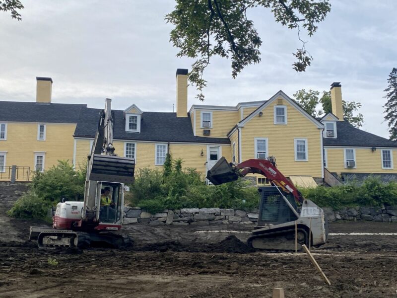 Two construction vehicles working to level the lawn off the Independence Center
