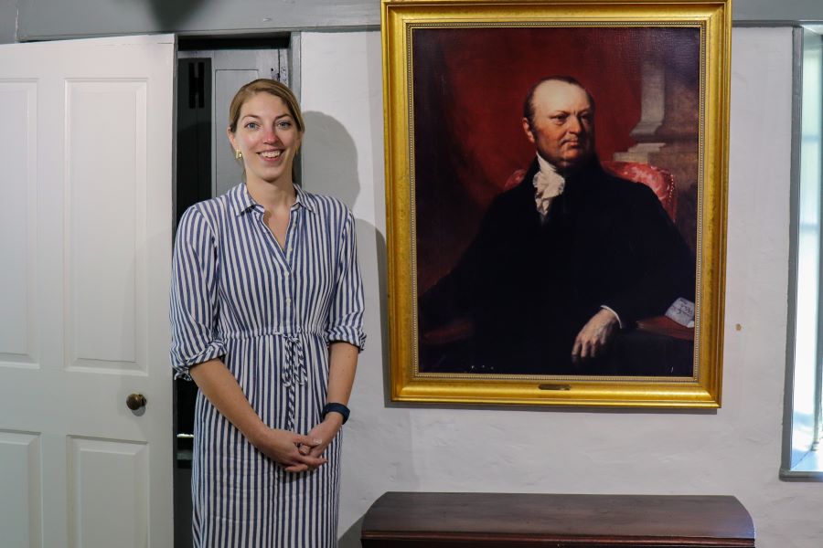 Center Directo Emma Stratton in front og a large oil portrait of John Taylro Gilman